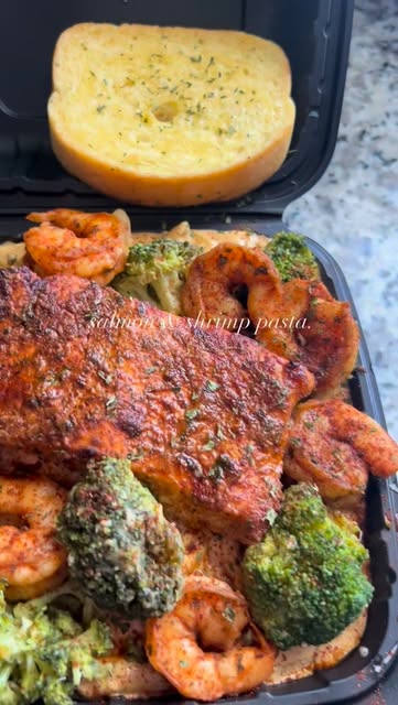 Blackened salmon and shrimp pasta with broccoli and garlic bread